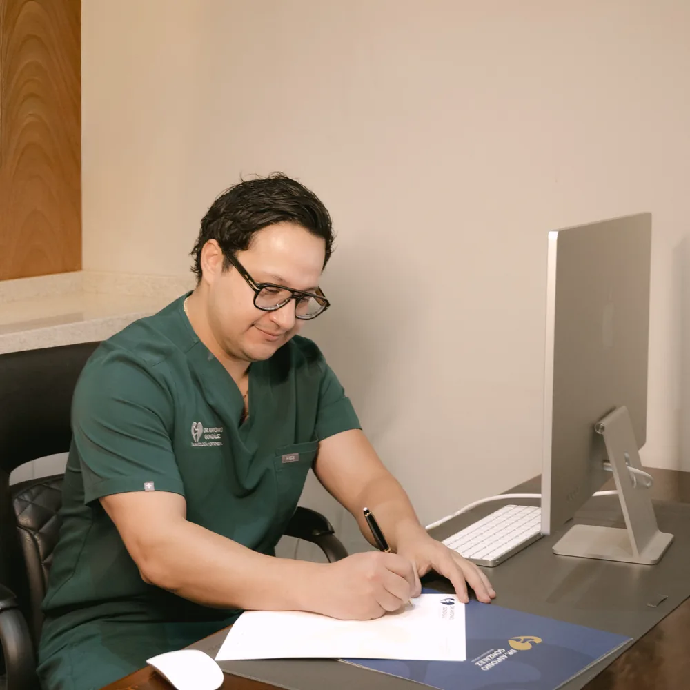 El Dr. González Tovar escribiendo un plan de tratamiento en su consultorio.